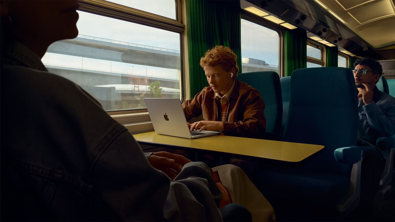 Člověk s AirPods Pro 3 v uších během cesty vlakem.