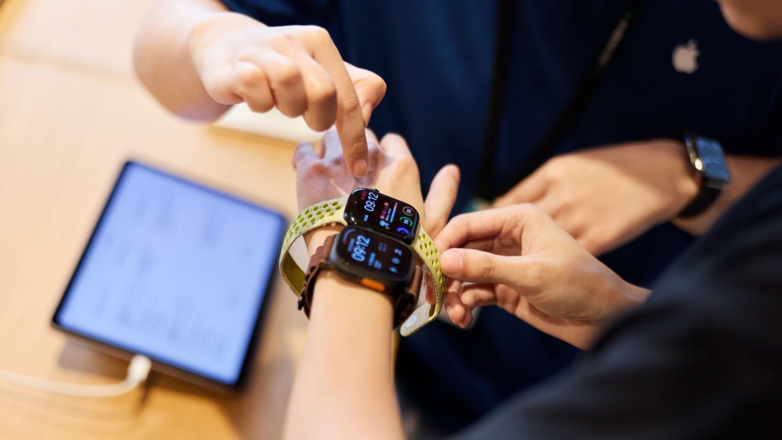 Detailní záběr zápěstí zákazníka zkoušejícího nejnovější modely Apple Watch v prodejně Apple Jing'an