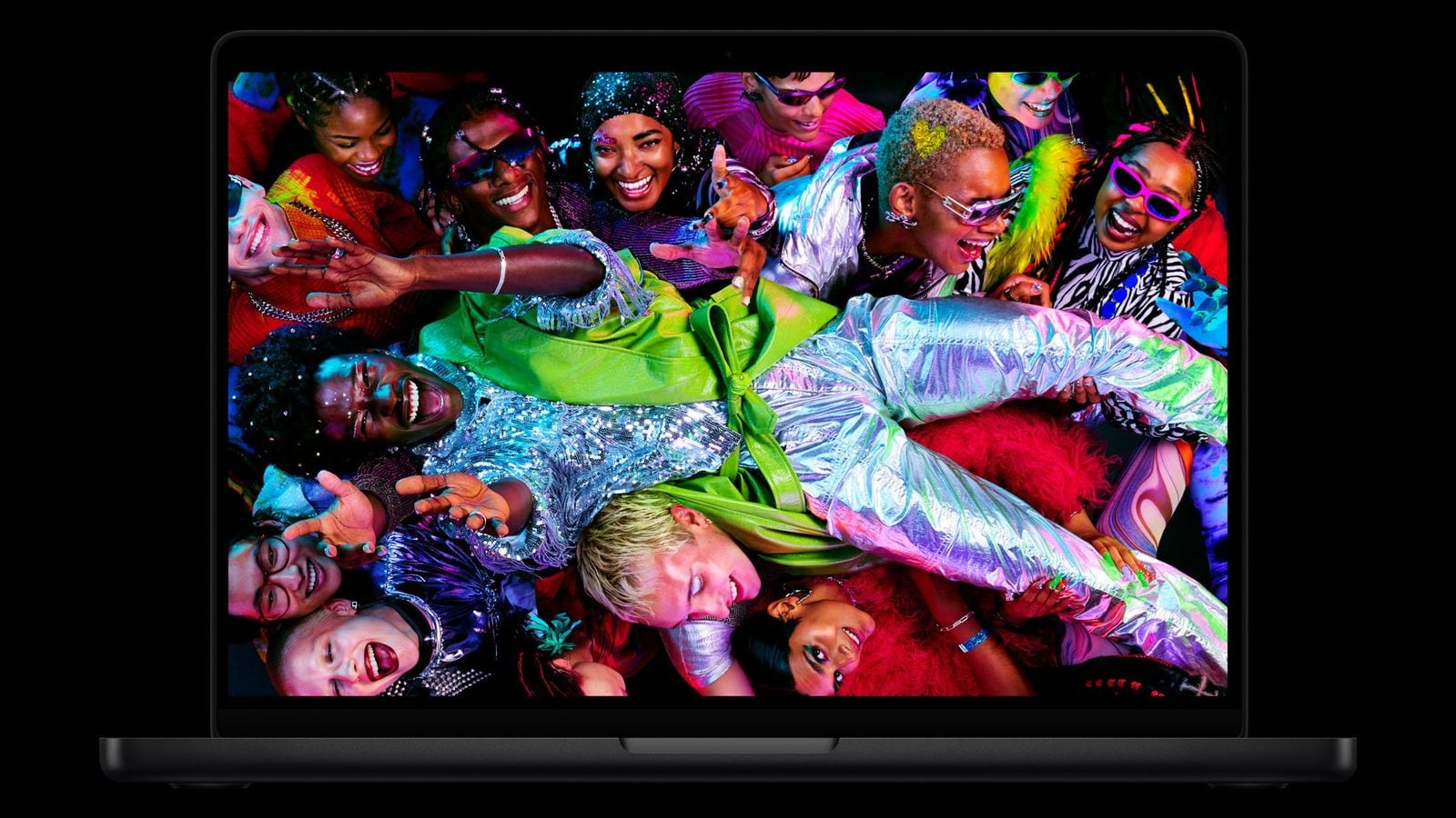 MacBook Pro s barevnou obrazovkou, na které je dav lidí v pestrém oblečení.