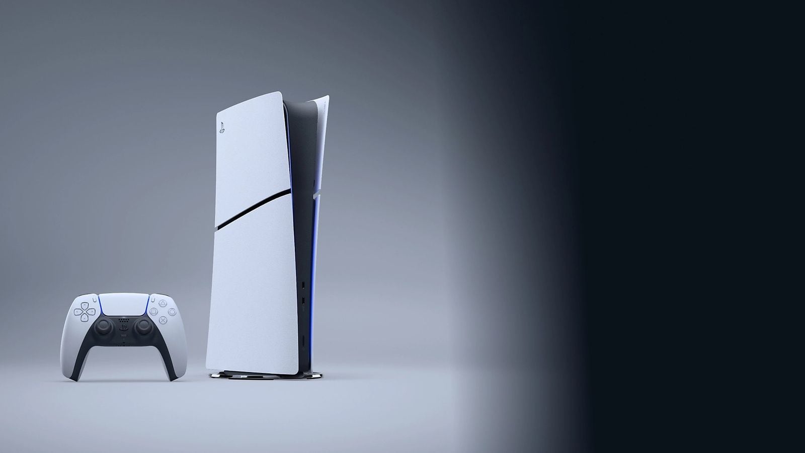 PS5 Slim konzole stojící vzpřímeně s bílým DualSense ovladačem, pohled zepředu zboku, šedé pozadí